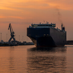 Obraz premium Large ferry turning gracefully in Malmö harbor under soft golden summer morning light
