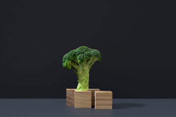 Florete fresco de brócoli colocado sobre piezas de madera sobre fondo gris oscuro