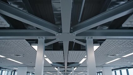 Repetitive patterns on an office ceiling grid, tracking shot along steel beams
