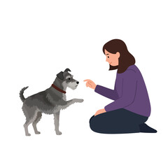 A woman in purple kneels, pointing at a grey dog extending a paw. The dog wears a red collar
