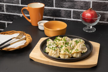 Delicious dumplings served on a black plate in a cozy dining setting
