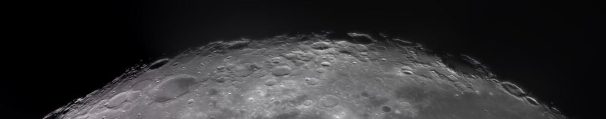 Panoramic view of the Moon surface, showing intricate details of its craters and rugged terrain. The image captures the texture, shadows, and natural formations of the lunar landscape.