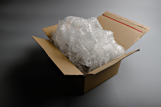 Open cardboard box completely filled with transparent bubble wrap showing maximum protective cushioning for safe product shipping and delivery