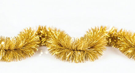 Close up of a shiny gold tinsel garland on a bright white surface