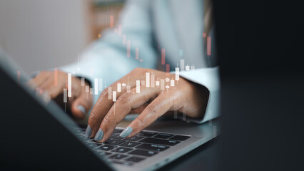 Business person typing on laptop with stock market candlestick chart for financial analysis and trading concept