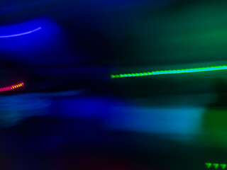 Elegant neon colored lines of light cut through the darkness of the night, giving a futuristic and dynamic impression of speed and movement, like a stunning digital abstract painting
