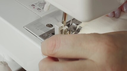 senior woman tailor sewing clothes using sewing machine, process of creating dress. Close-up hands seamstress's fabric stitching. female fashion designer work. elderly lady hobby home workshop space