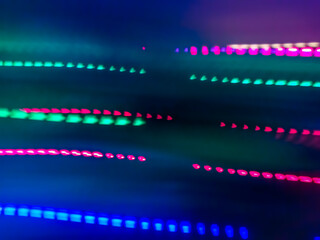 Elegant neon colored lines of light cut through the darkness of the night, giving a futuristic and dynamic impression of speed and movement, like a stunning digital abstract painting