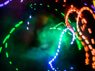 Colorful light particles form digital curves and dots in a light painting effect, creating an energetic and futuristic background.