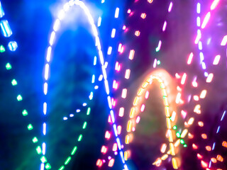 Colorful light particles form digital curves and dots in a light painting effect, creating an energetic and futuristic background.