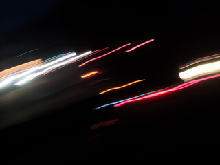 Elegant neon colored lines of light cut through the darkness of the night, giving a futuristic and dynamic impression of speed and movement, like a stunning digital abstract painting