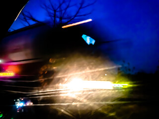 The glossy, reflective surface reflects intense light with a spectrum of bright colors such as purple, orange, and green, creating a dynamic and surreal abstract scene.