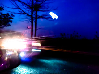 The glossy, reflective surface reflects intense light with a spectrum of bright colors such as purple, orange, and green, creating a dynamic and surreal abstract scene.