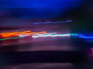 Elegant neon colored lines of light cut through the darkness of the night, giving a futuristic and dynamic impression of speed and movement, like a stunning digital abstract painting