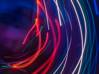Colorful light particles form digital curves and dots in a light painting effect, creating an energetic and futuristic background.