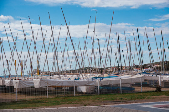 Marina with boats and sailboat masts on the shore