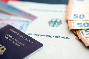 German passport and an identity card on an official naturalization certificate. Symbolic for successful acquisition of German citizenship close up