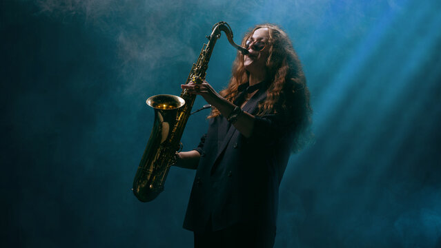 Saxophonist performing in blue light haze with emotional energy and deep focus. Concept of music performance, emotional psychology, motivational art, and creative storytelling.