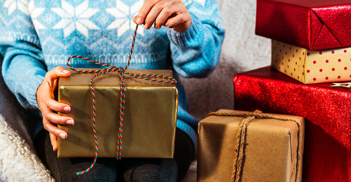 Female person unpacking gift boxes at home.