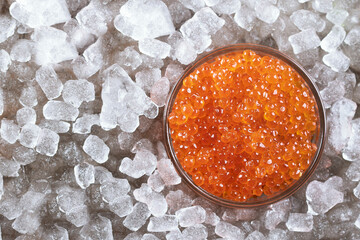 Red salmon caviar. Red fish roe in a glass container. Raw seafood. Natural omega. An exquisite luxury dish. White background. Flat lay. Top view. Copy space.