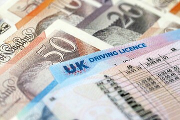 United Kingdom driving license card on UK British pounds money close up