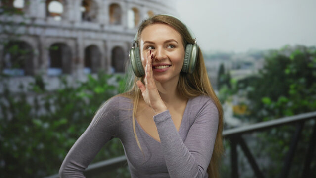 Woman smiling listens with headphones in front of the roman coliseum, suggesting a secretive conversation amid historical ruins, blending modern leisure with ancient architecture. - Powered by Adobe