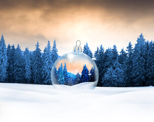 Gläserne WEihnachtskugel mit Wintermotiv in einer Bewaldeten Schneelandschaft