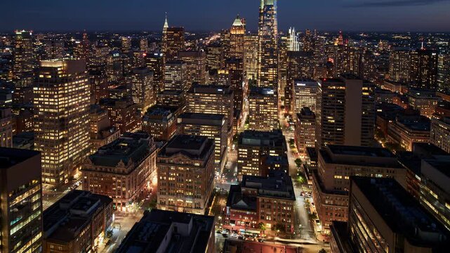 Ultra-wide time-lapse video of a bustling global financial district cityscape, dynamic transition from golden hour sunset to electrified night, dazzling lights, sharp focus, smooth light trails.
