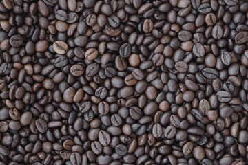 Pile of fresh roasted brown coffee beans close up. Food photo for backdrops