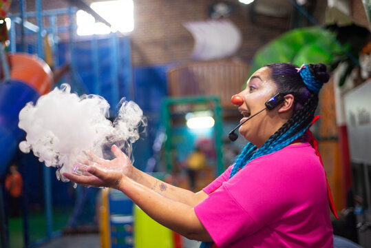 Mujer payaso haciendo burbujas de humo