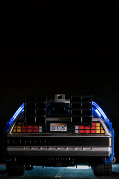 Madrid, Spain; October 25, 2025: Rear view of a Playmobil DeLorean toy featuring the iconic OUTATIME license plate, glowing blue lights and dark cinematic lighting