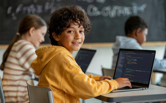 Smiling Student Learning to Code on a Laptop in a Classroom
