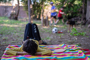 Ni&ntilde;o recostado en lona colorida en un parque 