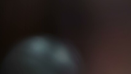 Abstract organic lens flare light leak bokeh overlay effect with colorful shimmering particles moving across dark background - Powered by Adobe