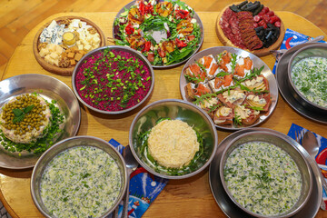 Olivier salad, sandwiches, canapés, bruschetta. A Christmas scene with meat delicacies against a dark wood background. An assortment of cheese and meat appetizers.