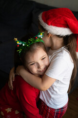 Sisters in Christmas pajamas hug each other