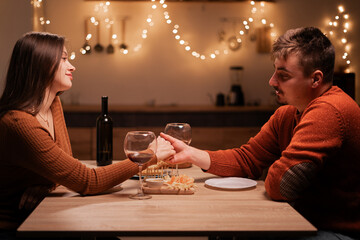 Happy young couple during their date at home, man holding his girlfriend's hand