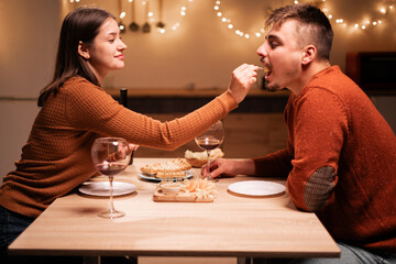 Celebrating Valentines day or anniversary. couple in love having romantic dinner date sitting at table woman feeding her man.