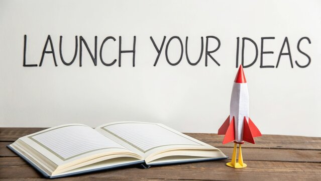 Paper rocket next to notepad symbolizing launch of ideas
