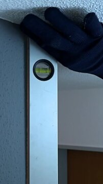 Checking wall alignment using a level tool in a home renovation project