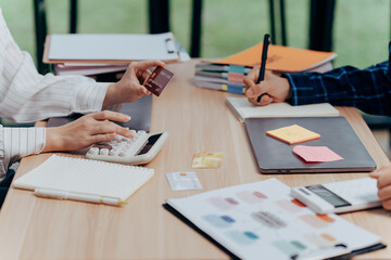 Financial Synergy: Business professionals collaborate over financial documents, analyzing data, calculating figures, and planning strategies, embodying teamwork and financial intelligence.