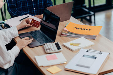 Financial planning and teamwork at the office: Two individuals are actively engaged in...