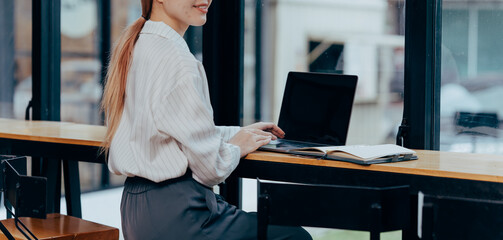 Focused Work: A professional woman is immersed in her work, sitting at a sleek counter, where her...