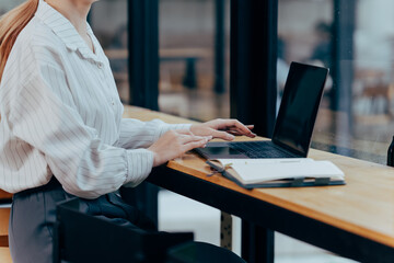 Working Smart in Modern Workplace: Focused individual using a laptop to streamline the business workflow in a contemporary office setting, optimizing productivity.