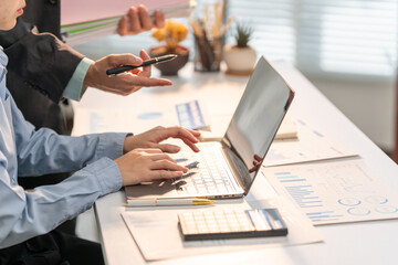 Collaboration and Analysis: Two professionals at a desk, with a laptop open and documents spread out, engaged in collaborative work and insightful analysis.