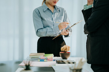 Business Discussion in Office: A focused interaction within an office setting, with a professional figure pointing to a document during a discussion.