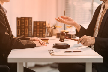 Legal Dialogue: A poised legal professional in a courtroom, holding a gavel and engaged in a focused discussion. A close-up view provides insight into the importance of decision-making.