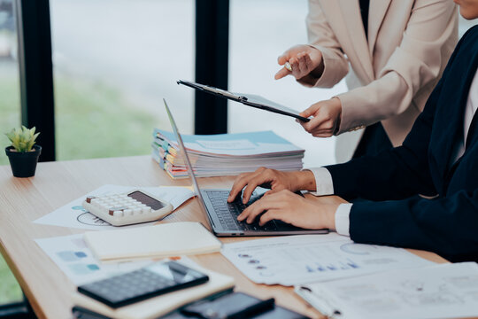 Collaborative Business Discussion: A focused business setting, where hands actively engage with the keyboard and documents, highlighting the essence of teamwork and data analysis. - Powered by Adobe