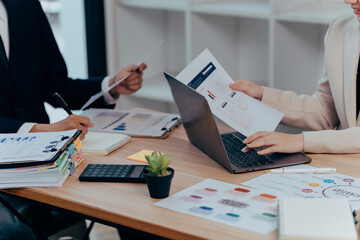 Navigating Digital Data: two professionals, engrossed in a discussion over data, analyzing information on a laptop, a business setup scene.