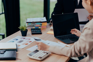 Teamwork and Technological Synergy: A dynamic collaborative scene unfolds as professionals engage in a focused meeting, meticulously reviewing data and reports.